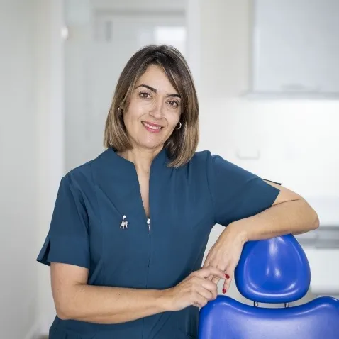 Mª José Iglesias, higienista de la Clínica Dental Moaña, junto a un sillón dental