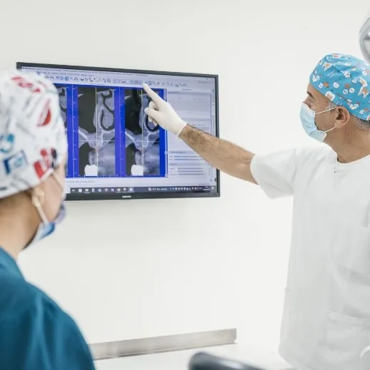 Dos profesionales de la Clínica Dental Moaña revisando radiografías en una pantalla